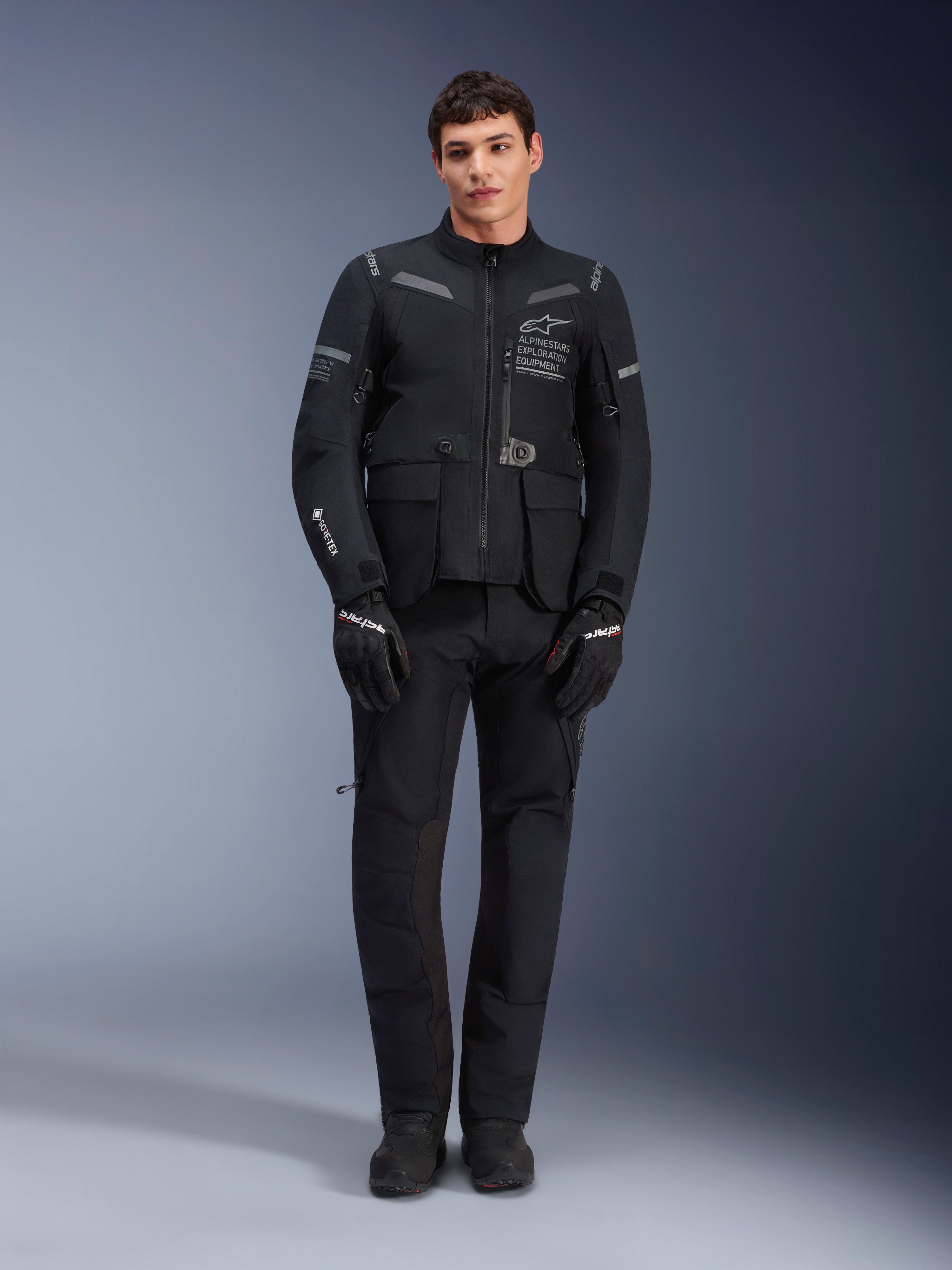 Pantaloni Alpinestars ST-7 2L GORE-TEX, pantaloni da moto touring neri, impermeabili e traspiranti, vista a figura intera indossati con giacca coordinata, costruzione tecnica premium per il turismo d'avventura