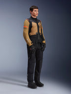 Giacca Alpinestars ST-7 2L GORE-TEX, giacca da moto, marrone Gobi e nero, indossata da un modello con pantaloni e guanti neri abbinati, con pannelli marroni sul torace e sulle maniche, accenti tecnici neri e loghi arancioni, abbigliamento da moto adventure-touring.