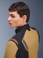 Giacca Alpinestars ST-7 2L GORE-TEX, giacca da moto, marrone Gobi e nero, vista di profilo di un uomo che indossa la giacca, con logo arancione sulla spalla, colletto alto con regolazione tramite cordino elastico e marchio Tech-Air