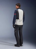 Modello che indossa la giacca Alpinestars ST-7 2L GORE-TEX in Ice Gray Dark Blue e Black, vista posteriore, pannello posteriore grigio chiaro con logo Alpinestars, maniche blu scuro con striscia rossa, abbinata a pantaloni e stivali da moto adventure neri, abbigliamento da moto touring