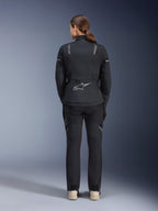 Giacca Alpinestars Stella ST-7 2L GORE-TEX da donna, nero e grigio scuro, vista posteriore con logo Alpinestars argento sulla parte bassa della schiena, abbinata a pantaloni in tessuto neri coordinati, abbigliamento moto adventure touring