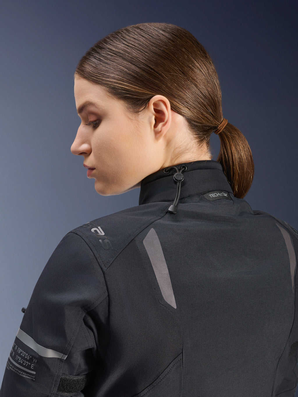 Giacca da moto Alpinestars Stella ST-7 2L GORE-TEX da donna, nera, vista laterale-posteriore che mostra la chiusura del collo regolabile con cordino elastico, dettagli riflettenti sulle spalle e marchio Tech-Air Ready, design funzionale per adventure touring