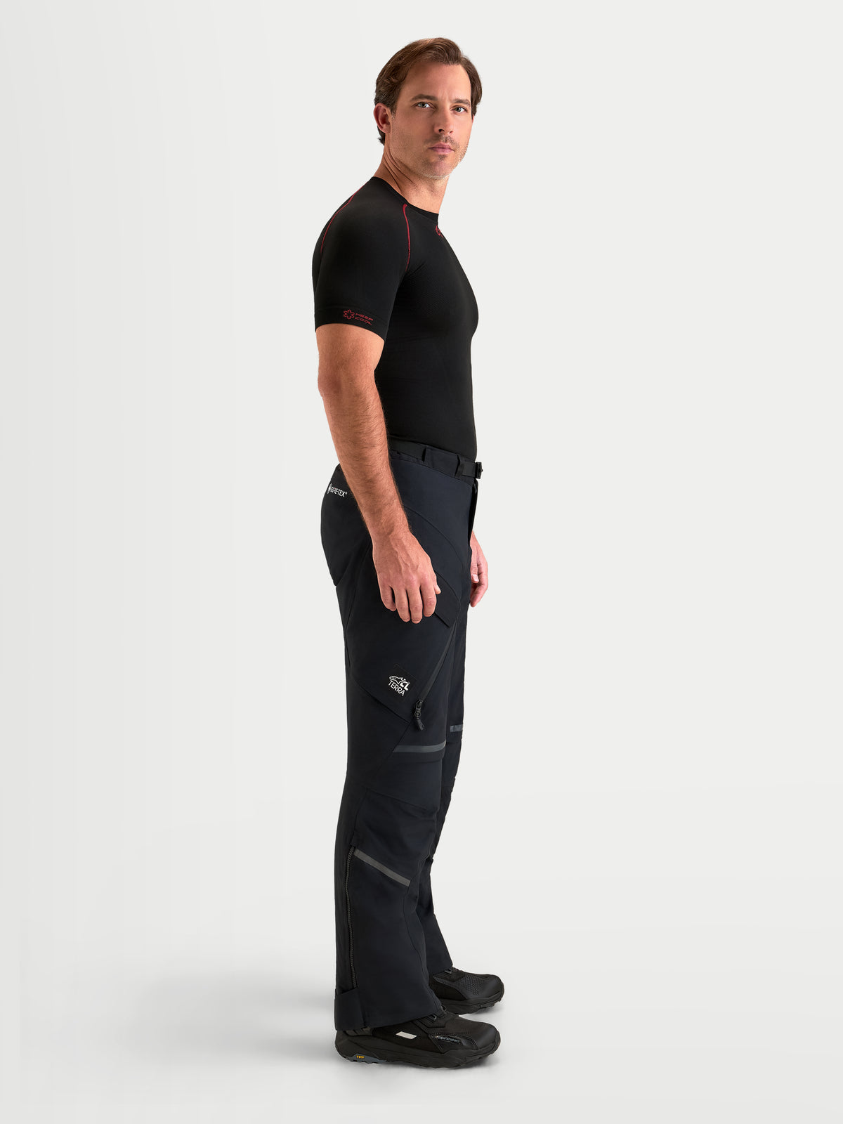 Alpinestars St 7 V 2 2 L Gore Tex Pantaloni Short, pantaloni da moto adventure da uomo, colore nero, vista laterale su un modello che indossa abbigliamento da touring impermeabile
