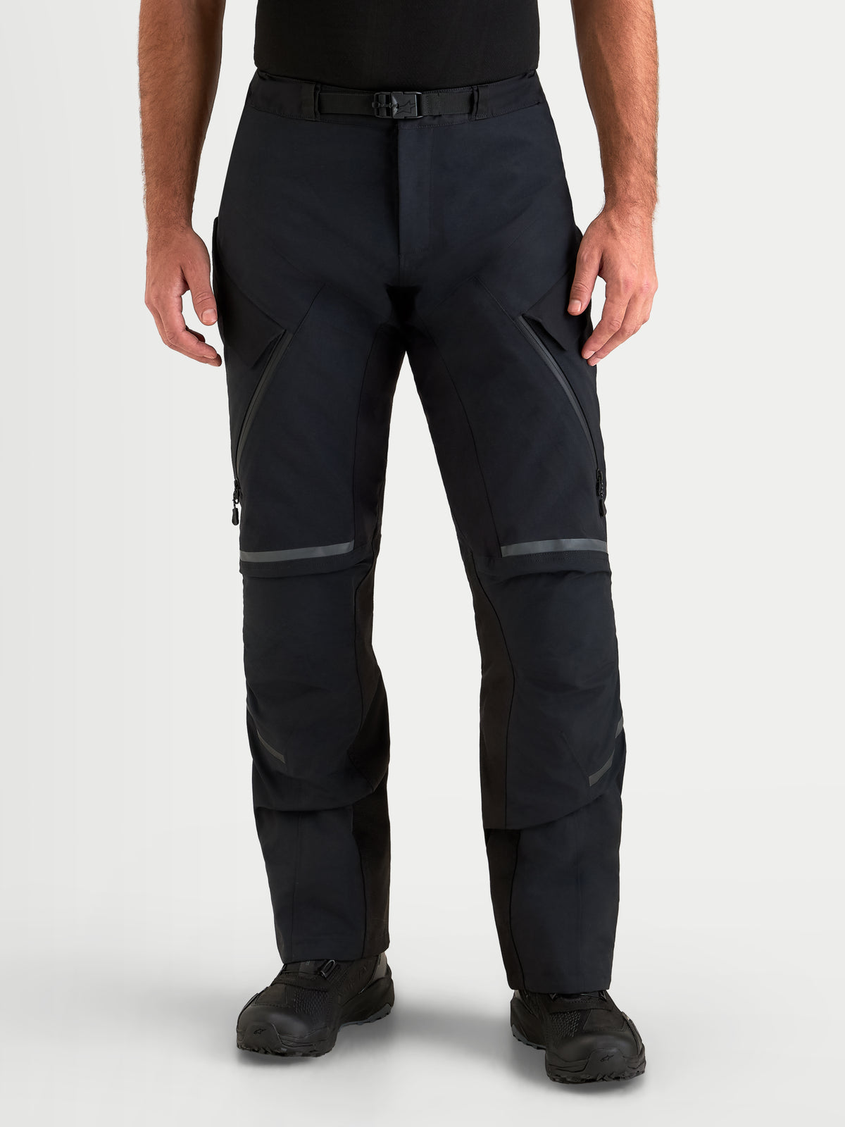 Alpinestars St 7 V 2 2 L Gore Tex Pantaloni, pantaloni da moto adventure da uomo, colore nero, vista frontale su un modello che indossa abbigliamento impermeabile con chiusura magnetica in vita e cerniere di ventilazione sulle cosce
