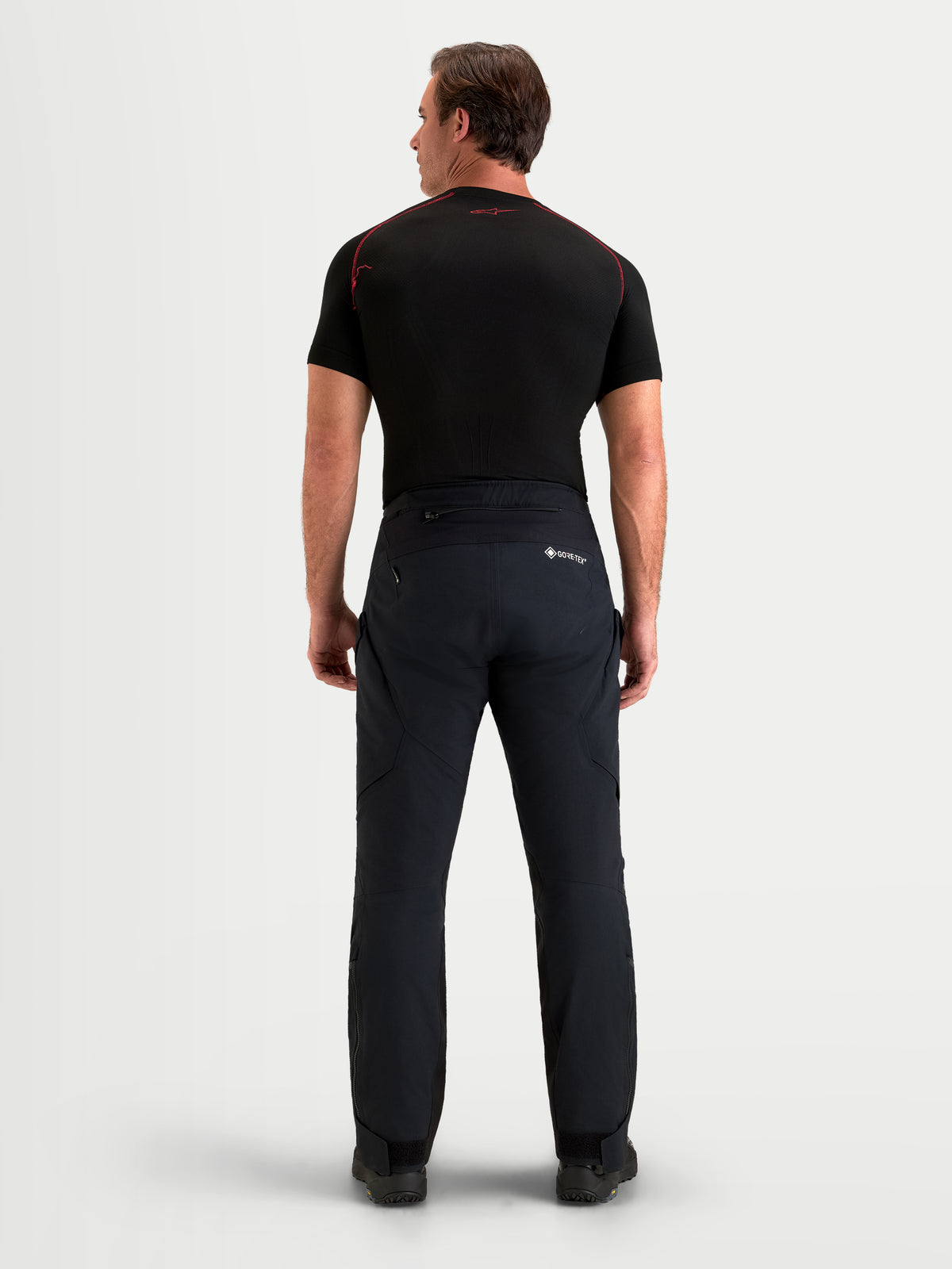 Alpinestars St-7 V2 2L Gore-Tex Pantaloni Short, pantaloni da moto adventure da uomo, colore nero, vista posteriore con abbigliamento in tessuto impermeabile e top scuro abbinato