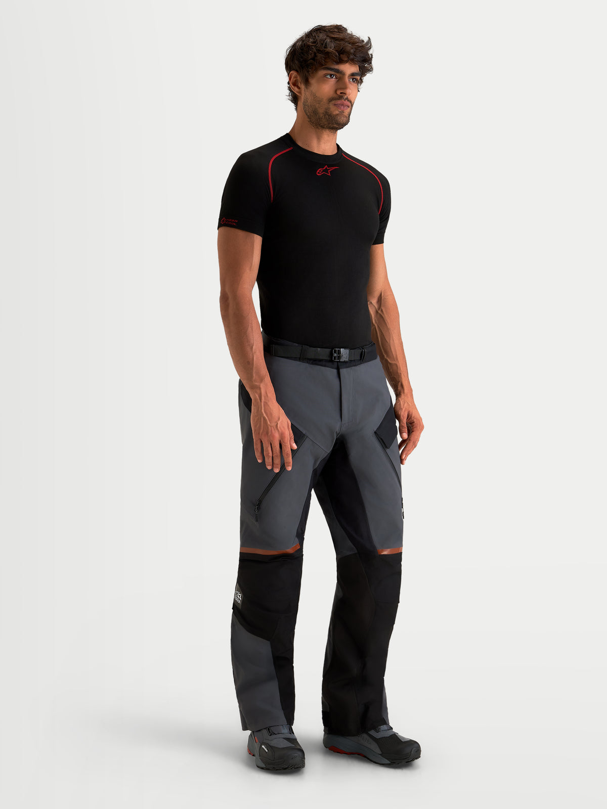 Alpinestars St 7 V 2 2 L Gore Tex Pantaloni, pantaloni da moto adventure da uomo, grigio scuro e nero, vista frontale su un modello che indossa attrezzatura da touring impermeabile con prese d’aria con zip sulle cosce