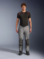Pantaloni Alpinestars Nazca 3L GORE-TEX PRO, pantaloni da moto adventure, grigio e nero, indossati da un modello con base layer nero, caratterizzati da pannelli rinforzati sulle ginocchia, marchio GORE-TEX PRO e un design in tessuto robusto per il touring in ogni condizione climatica