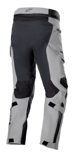 Pantaloni Alpinestars Boulder 3L GORE-TEX, pantaloni da moto adventure, grigio scuro e nero, vista posteriore a tre quarti che mostra la seduta e l'interno gamba rinforzati, pannelli grigio chiaro, logo GORE-TEX sul polpaccio e tasche cargo ergonomiche.
