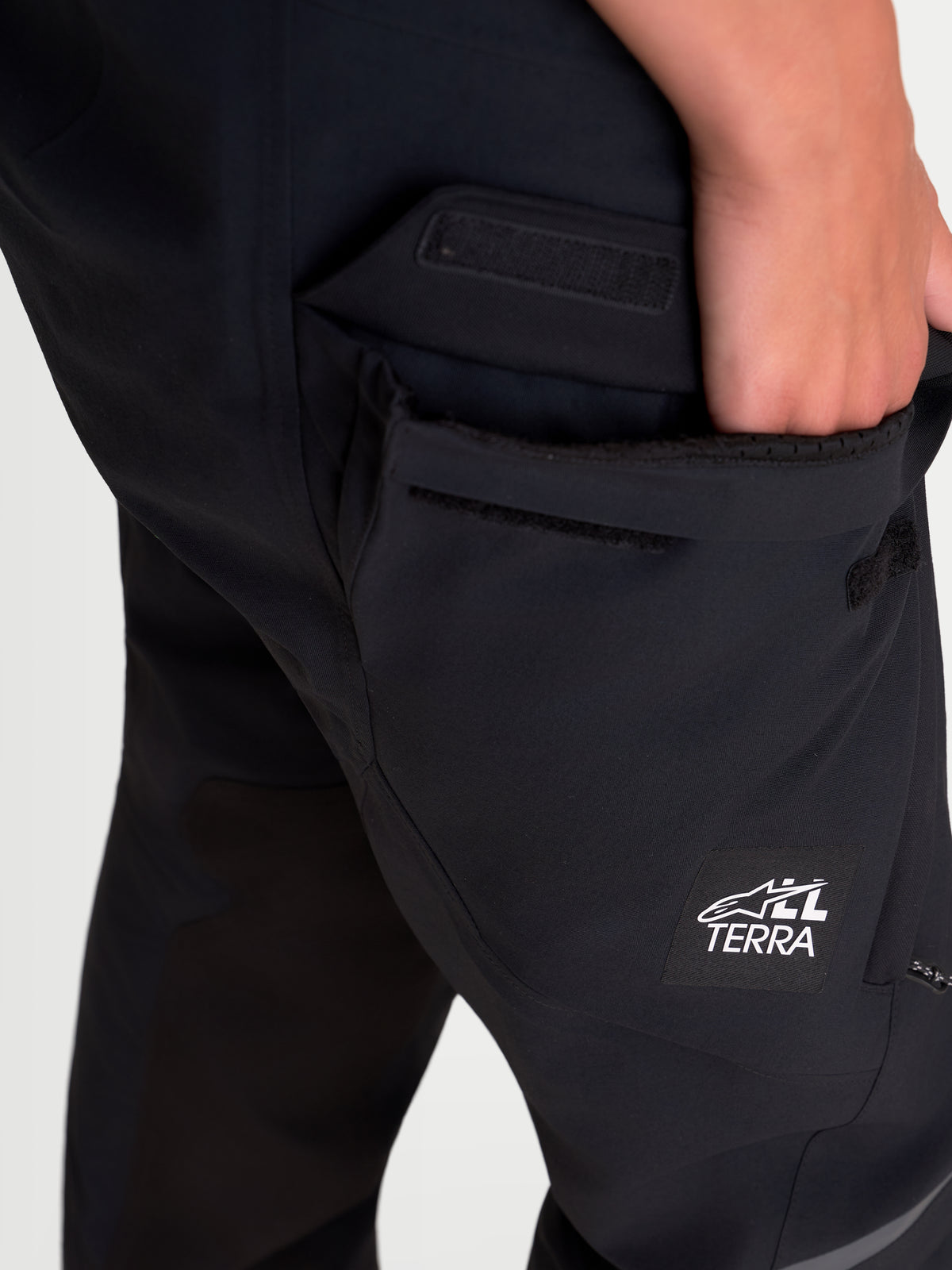 Alpinestars Stella St 7 V 2 2 L Gore Tex Pantaloni, pantaloni da moto adventure da donna, nero, dettaglio ravvicinato che mostra la tasca cargo impermeabile e il marchio All Terra
