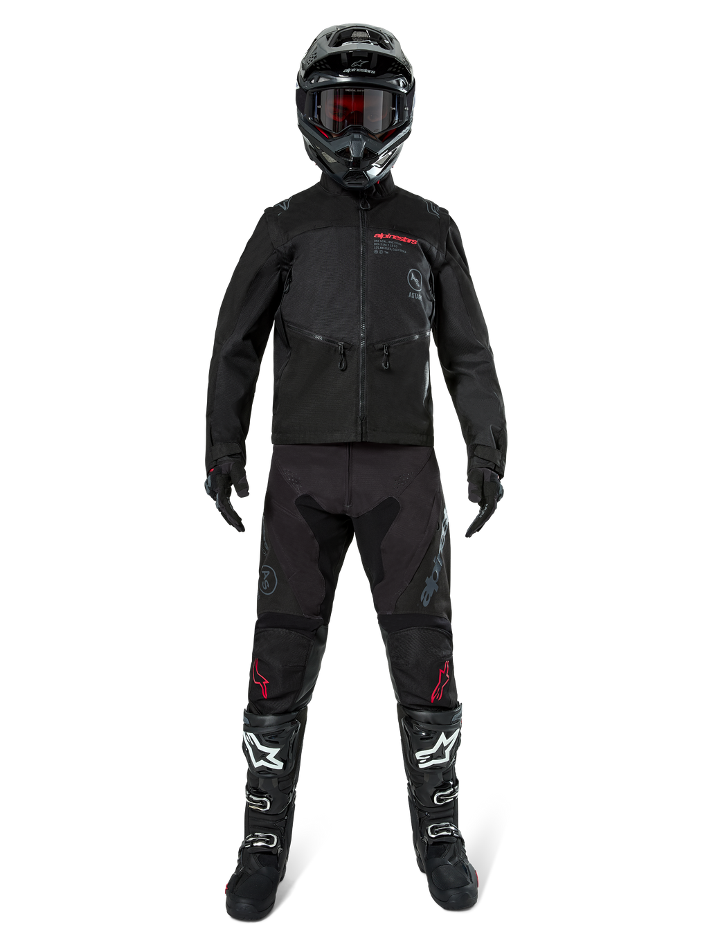 Giacca Alpinestars Pro-Dura, giacca nera da enduro off-road, mostrata su un modello con un set completo di attrezzatura che include casco nero con maschera rossa, pantaloni neri con dettagli rossi, stivali neri e bianchi e guanti neri, design robusto ispirato al rally per trail riding