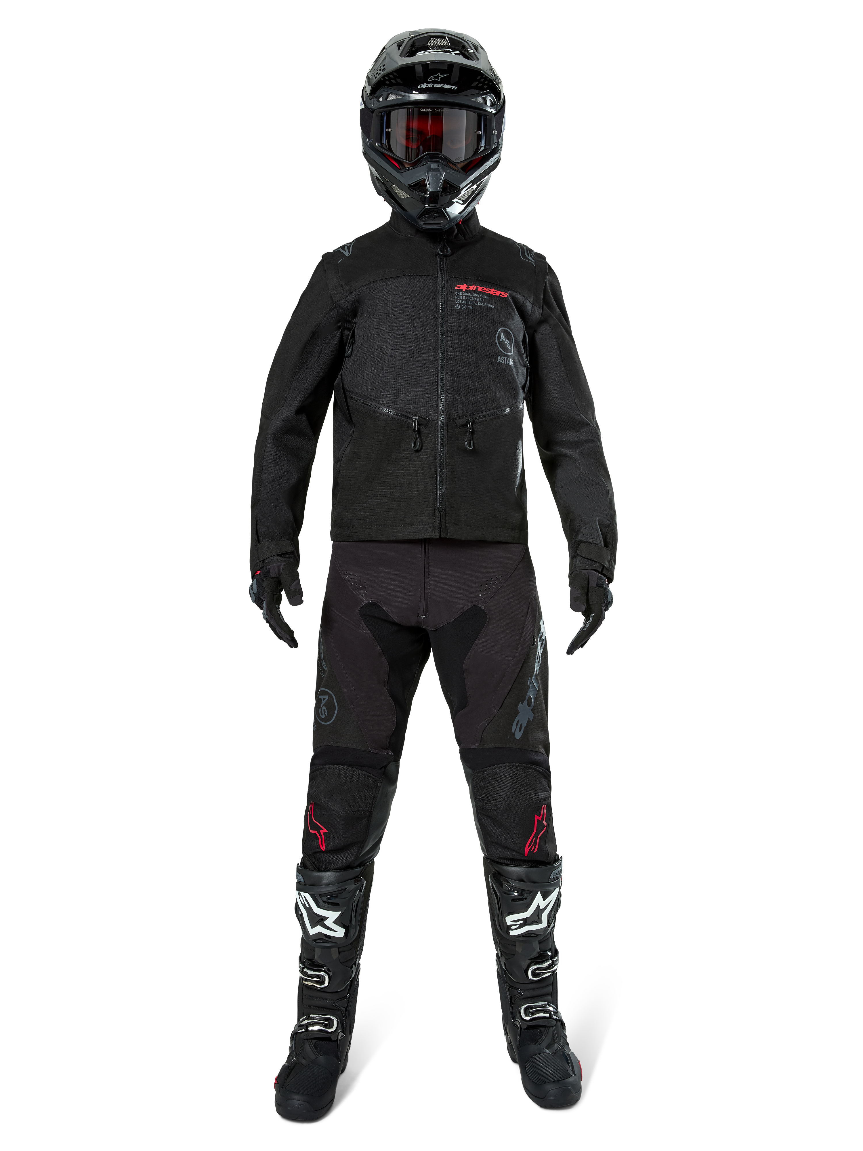 Giacca Alpinestars Pro-Dura, giacca nera da enduro off-road, mostrata su un modello con un set completo di attrezzatura che include casco nero con maschera rossa, pantaloni neri con dettagli rossi, stivali neri e bianchi e guanti neri, design robusto ispirato al rally per trail riding
