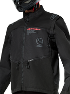 Giacca Alpinestars Pro-Dura, giacca da moto fuoristrada nera con branding Alpinestars rosso e logo Astars circolare grigio sul petto, tasche con zip, resistente costruzione in tessuto ripstop, design ispirato ai rally per l'enduro