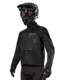 Alpinestars Pro-Dura Jacket, giacca da moto off-road, nera con loghi rossi e grigi, tasche anteriori con zip e colletto alto, indossata con casco da motocross e guanti neri per gare di enduro