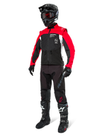 Giacca Alpinestars Pro-Dura, giacca da moto fuoristrada, nero, rosso acceso e bianco, indossata con abbigliamento completo da gara, inclusi casco nero con occhiali rossi, pantaloni neri e stivali bianchi e neri, completo in tessuto resistente per enduro e trail riding