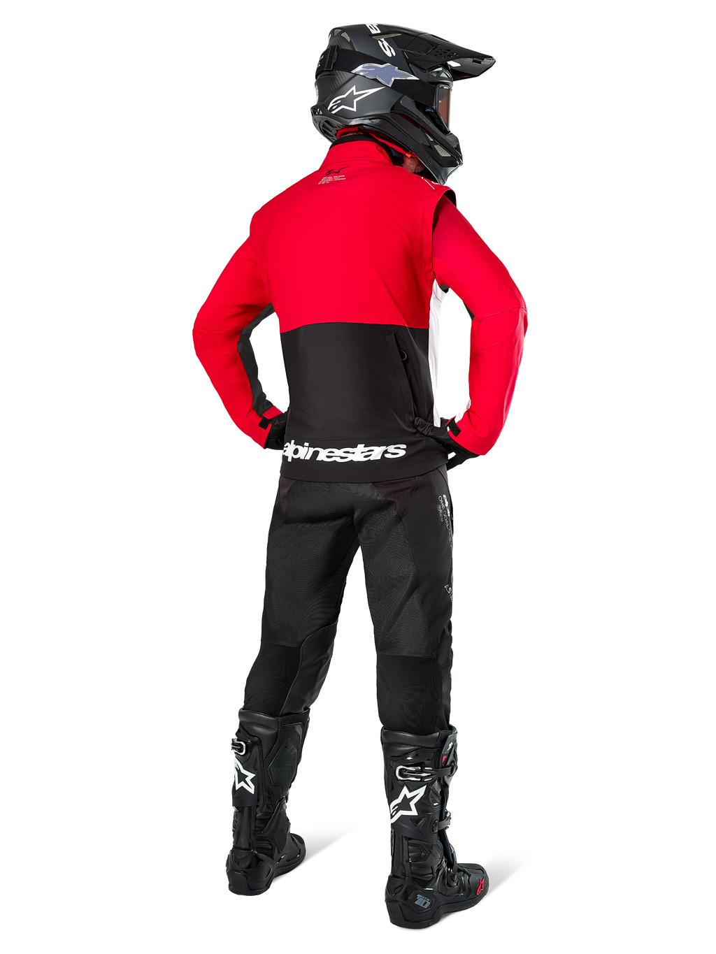 Pilota di motocross visto da dietro che indossa la Giacca Alpinestars Pro-Dura in nero, rosso acceso e bianco, abbinata a pantaloni neri, casco nero e stivali da fuoristrada neri, caratterizzata da una parte superiore rossa e una inferiore nera con logo Alpinestars bianco sulla schiena.