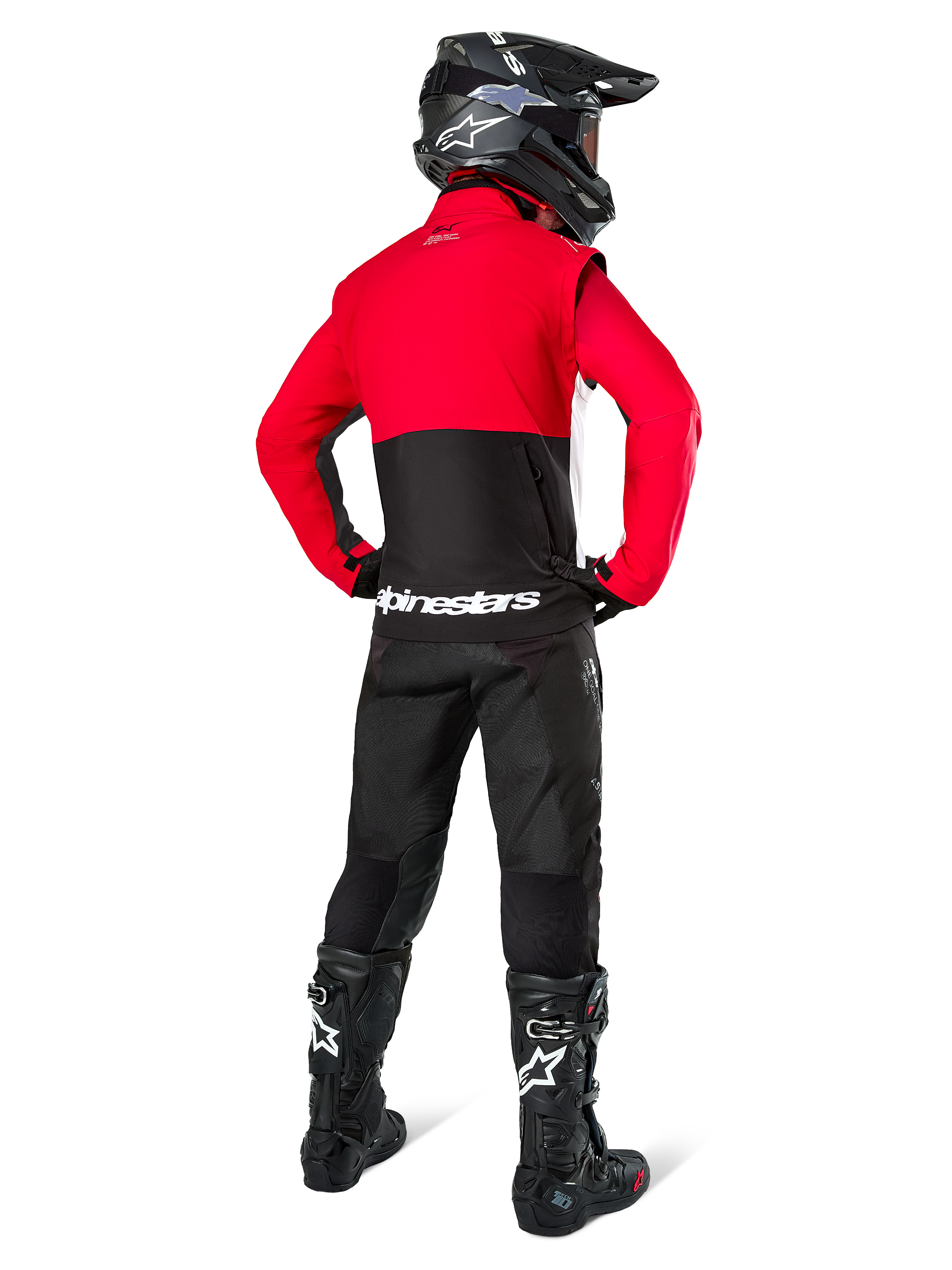 Pilota di motocross visto da dietro che indossa la Giacca Alpinestars Pro-Dura in nero, rosso acceso e bianco, abbinata a pantaloni neri, casco nero e stivali da fuoristrada neri, caratterizzata da una parte superiore rossa e una inferiore nera con logo Alpinestars bianco sulla schiena.