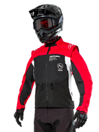 Giacca Alpinestars Pro-Dura, giacca da moto enduro fuoristrada, nero con blocchi di colore rosso acceso e bianco, indossata da un pilota con casco nero e maschera, dotata di tasche anteriori con zip e logo Alpinestars, struttura in tessuto resistente per trail riding
