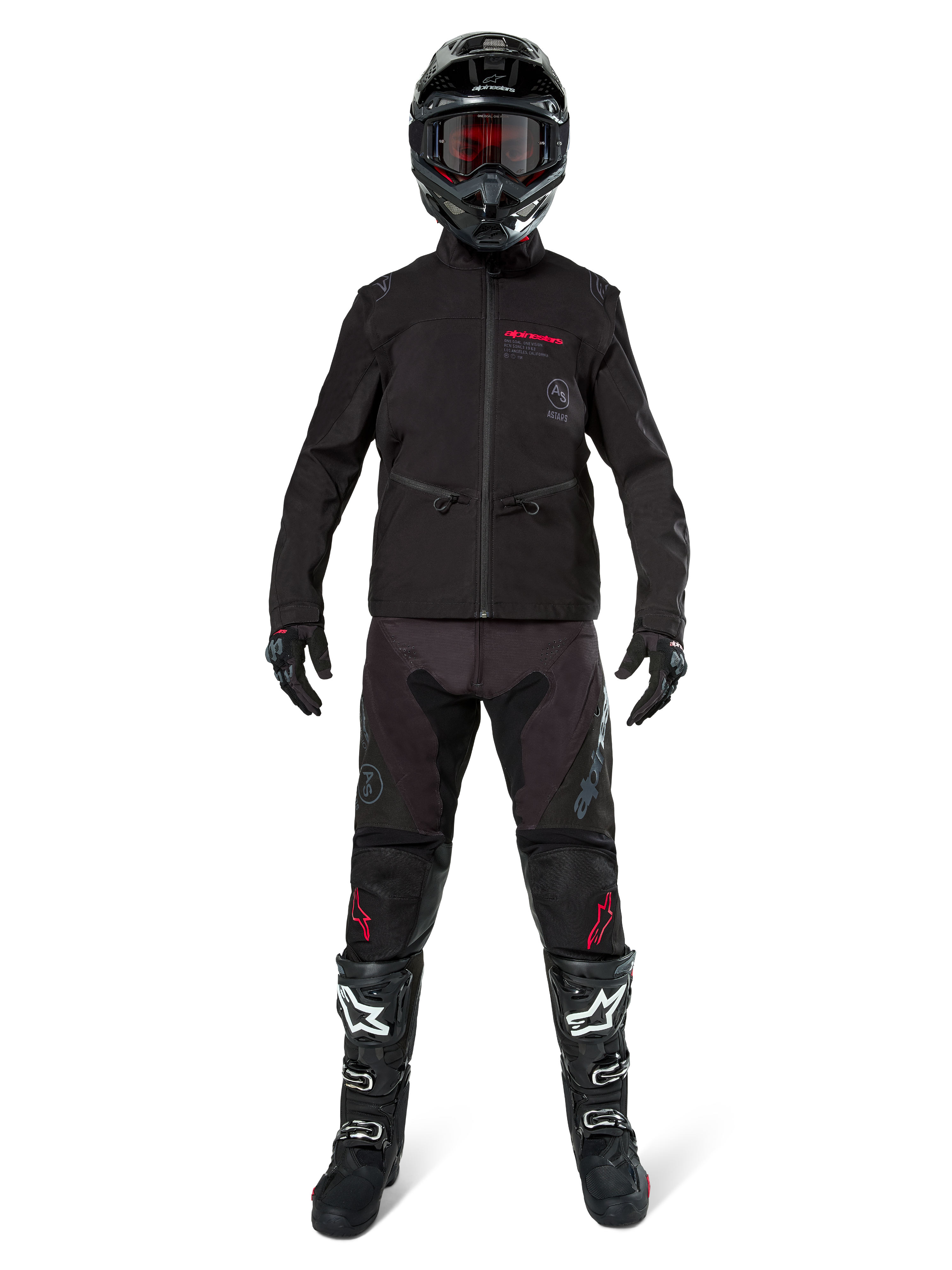 Pilota di motocross con Giacca Softshell Alpinestars Lite-Dura in nero e dettagli del logo rossi, abbinata a pantaloni off-road neri coordinati, casco nero e stivali bianchi e neri, abbigliamento professionale completo da enduro