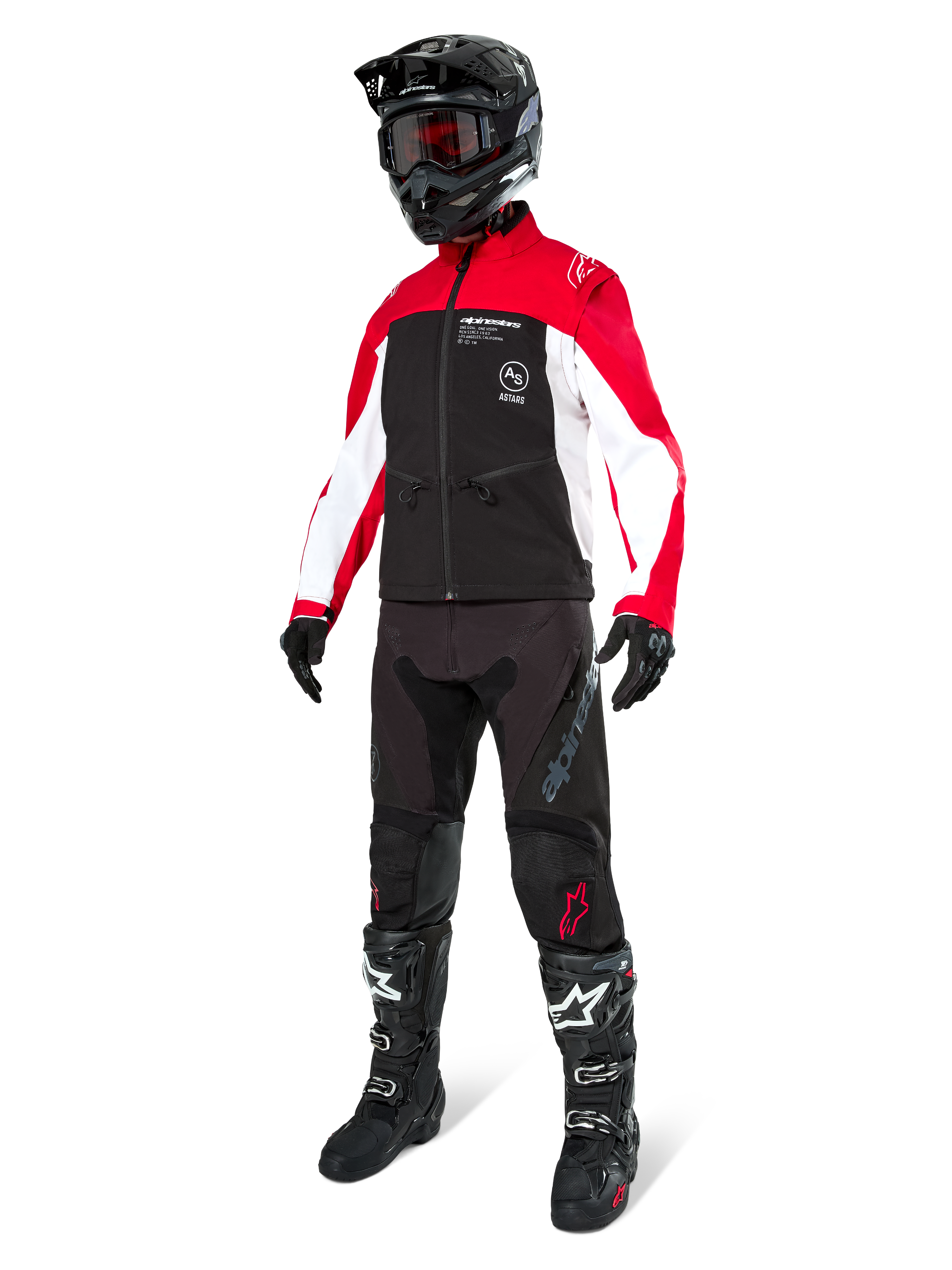 Pilota di motocross con Giacca Softshell Alpinestars Lite-Dura in nero, rosso brillante e bianco, caratterizzata da corpo nero e maniche rosse e bianche, abbinata a pantaloni neri, casco nero con occhiali rossi e stivali neri e bianchi, completo da corsa fuoristrada