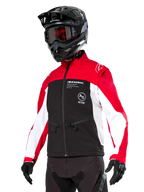 Giacca Softshell Alpinestars Lite-Dura, giacca da moto, nero, rosso acceso e bianco, indossata da un pilota con casco da motocross nero, occhiali rossi e guanti, con logo evidente sul petto, progettata per la guida off-road ed enduro