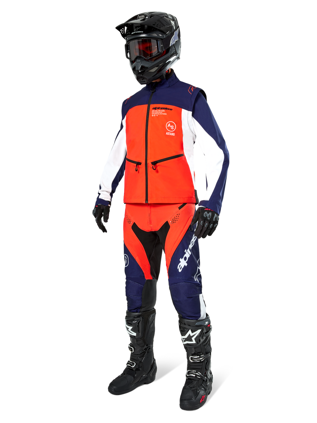 Pilota di motocross con giacca softshell Alpinestars Lite-Dura in blu navy, arancione e bianco, pantaloni da fuoristrada coordinati, casco nero con maschera e stivali da gara neri, set di abbigliamento da enduro coordinato