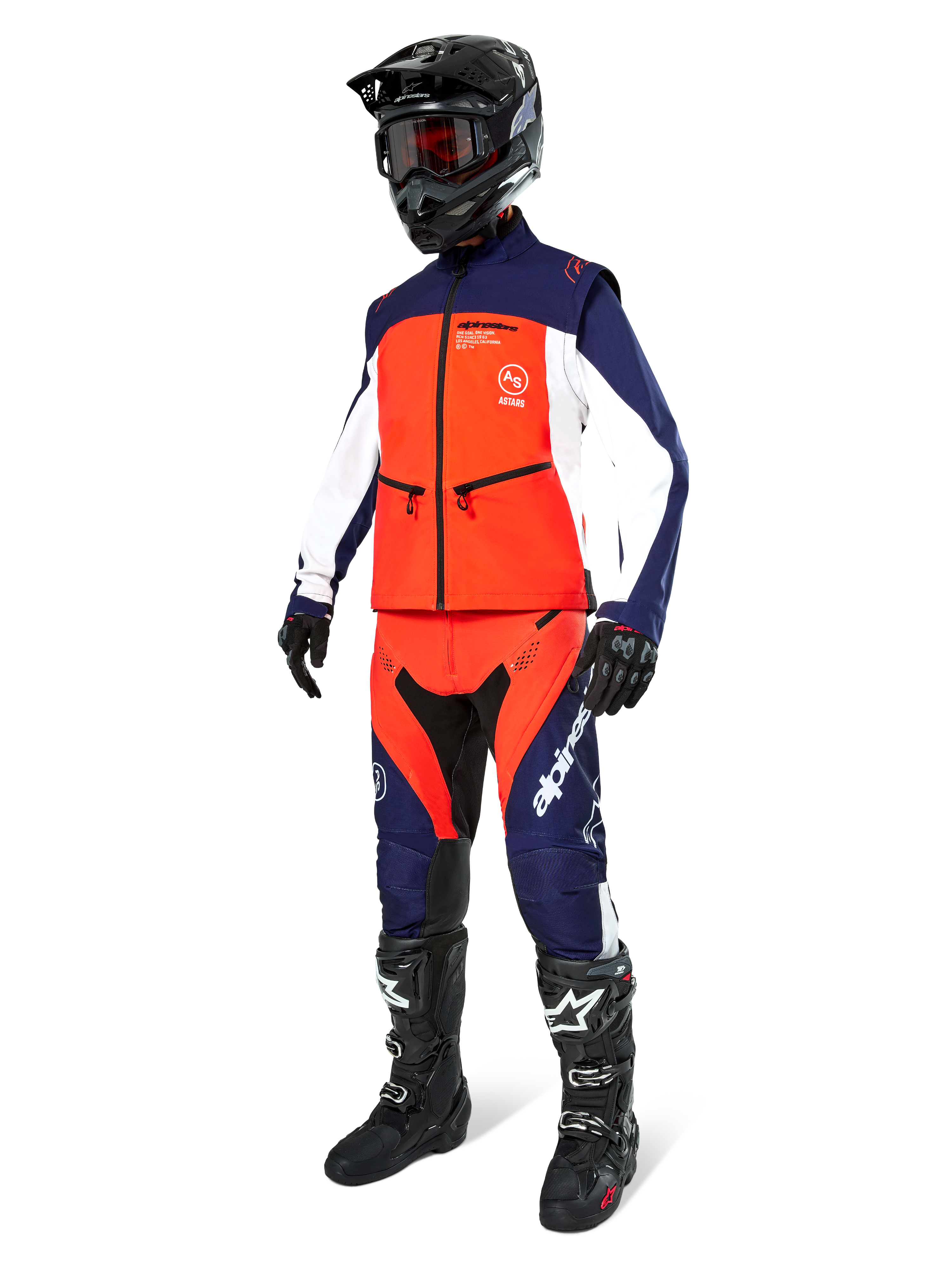 Pilota di motocross con giacca softshell Alpinestars Lite-Dura in blu navy, arancione e bianco, pantaloni da fuoristrada coordinati, casco nero con maschera e stivali da gara neri, set di abbigliamento da enduro coordinato