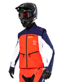 Giacca Softshell Alpinestars Lite-Dura in blu navy, arancione acceso e bianco, abbigliamento da motocross, indossata con casco e maschera neri, guanti protettivi e pantaloni da gara coordinati