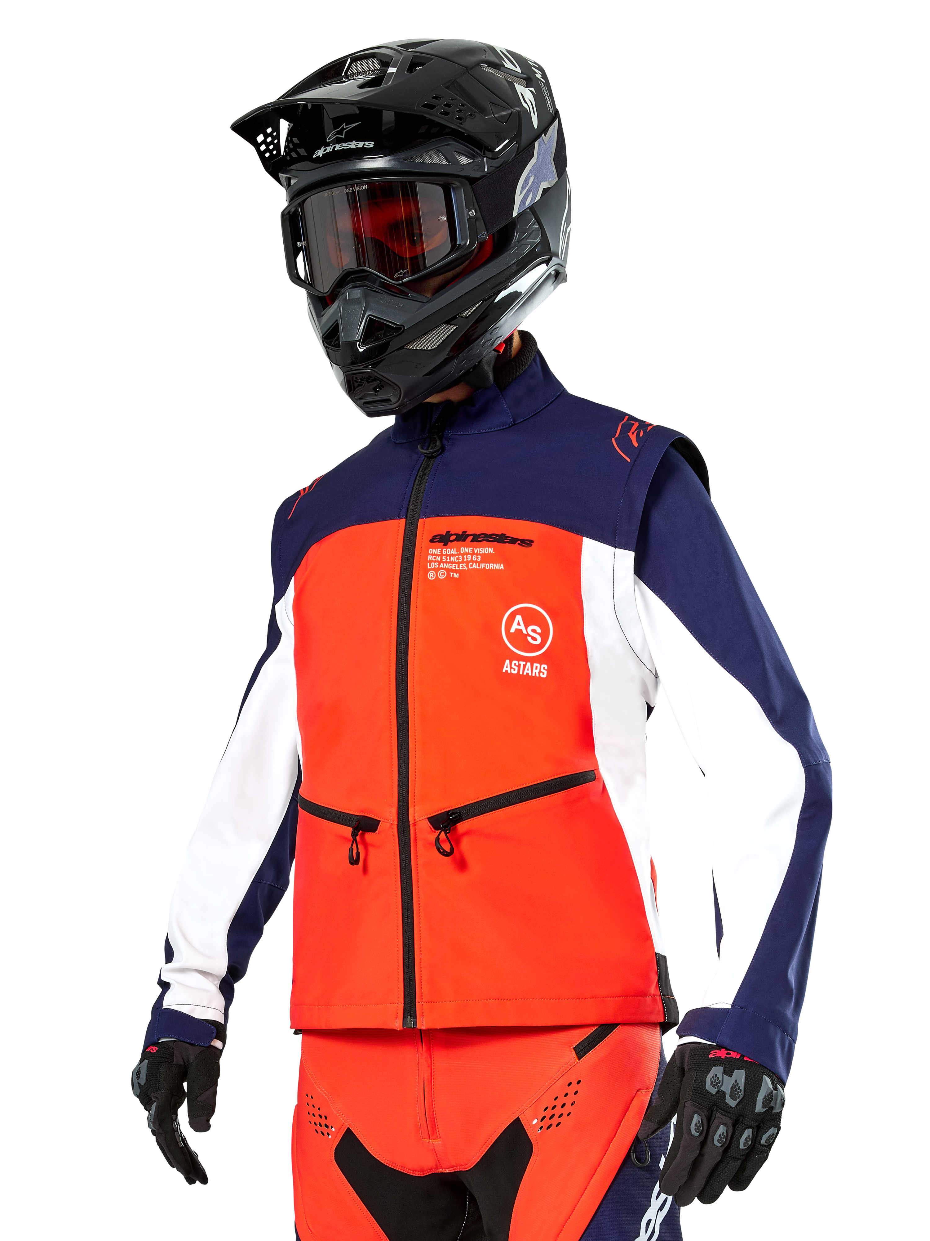 Giacca Softshell Alpinestars Lite-Dura in blu navy, arancione acceso e bianco, abbigliamento da motocross, indossata con casco e maschera neri, guanti protettivi e pantaloni da gara coordinati