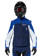 Pilota di motocross che indossa la Giacca Softshell Alpinestars Lite-Dura in Navy Bright Blue White, vista frontale, abbinata a un casco nero e una maschera con lenti rosse, caratterizzata da un design tecnico antivento con tasche con zip e dettagli bianchi per la guida enduro fuoristrada