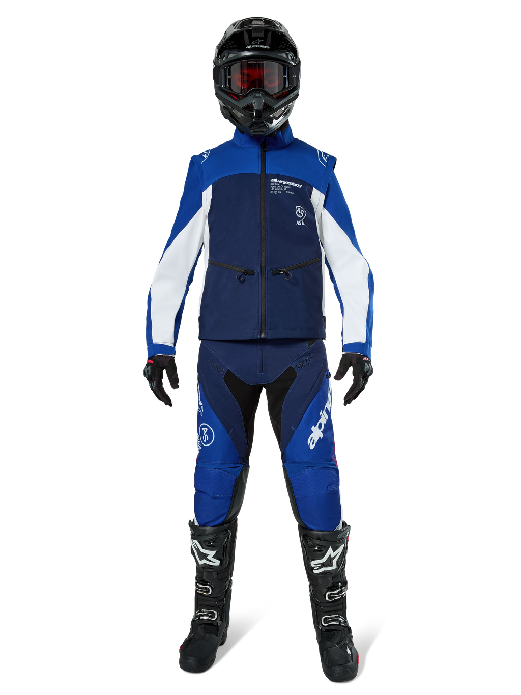 Giacca Softshell Alpinestars Lite-Dura, giacca da moto off-road in blu navy, azzurro e bianco, indossata con un set completo coordinato comprensivo di casco nero, pantaloni da enduro e stivali neri, abbigliamento tecnico antivento per guida fuoristrada