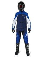 Giacca Softshell Alpinestars Lite-Dura, giacca da moto off-road in blu navy, azzurro e bianco, indossata con un set completo coordinato comprensivo di casco nero, pantaloni da enduro e stivali neri, abbigliamento tecnico antivento per guida fuoristrada