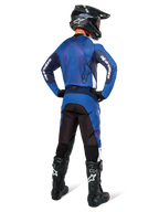 Alpinestars Pro-Dura Pants, pantaloni da motocross ed enduro, blu navy, azzurro e bianco, vista posteriore, indossati con maglia blu coordinata, casco nero e stivali Tech neri, costruzione robusta con inserti elastici per la guida off-road