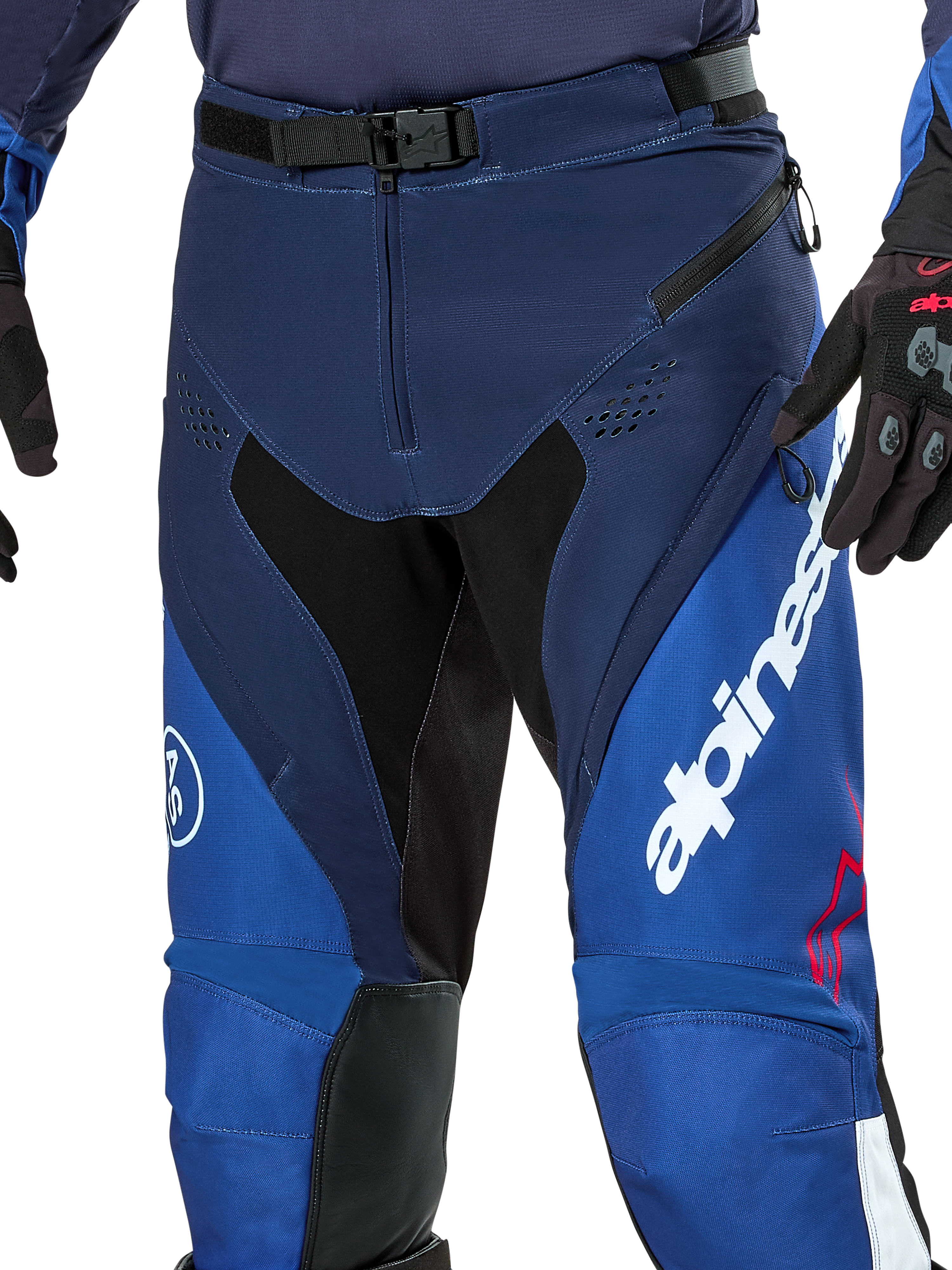 Alpinestars Pro-Dura Pants, pantaloni da enduro e motocross, blu navy, azzurro e bianco, vista ravvicinata della chiusura in vita con fibbia magnetica SX2, prese d'aria con zip sulle cosce e pannelli elasticizzati con logo bianco