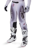 Alpinestars 2025 Supertech Maker Pants, pantaloni da motocross, argento e nero, con grandi loghi a stella e scritte rosse, mostrati con stivali e guanti bianchi coordinati