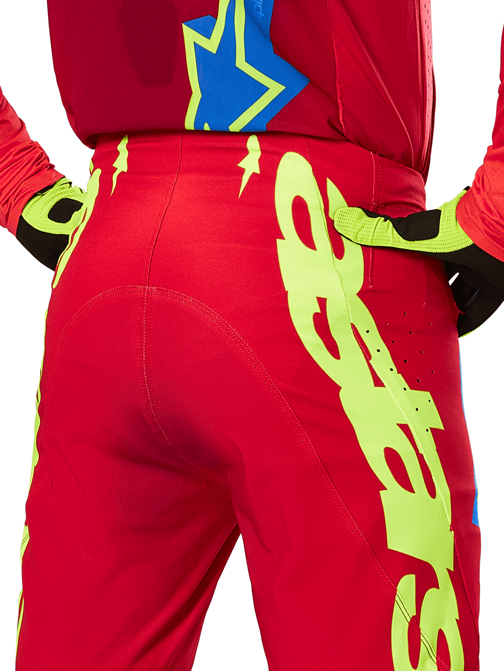 Alpinestars Pantaloni Supertech Maker 2025, pantaloni da motocross, rosso acceso e giallo fluo, primo piano posteriore con grafica giallo neon, indossati con maglia rossa coordinata e guanti gialli e neri