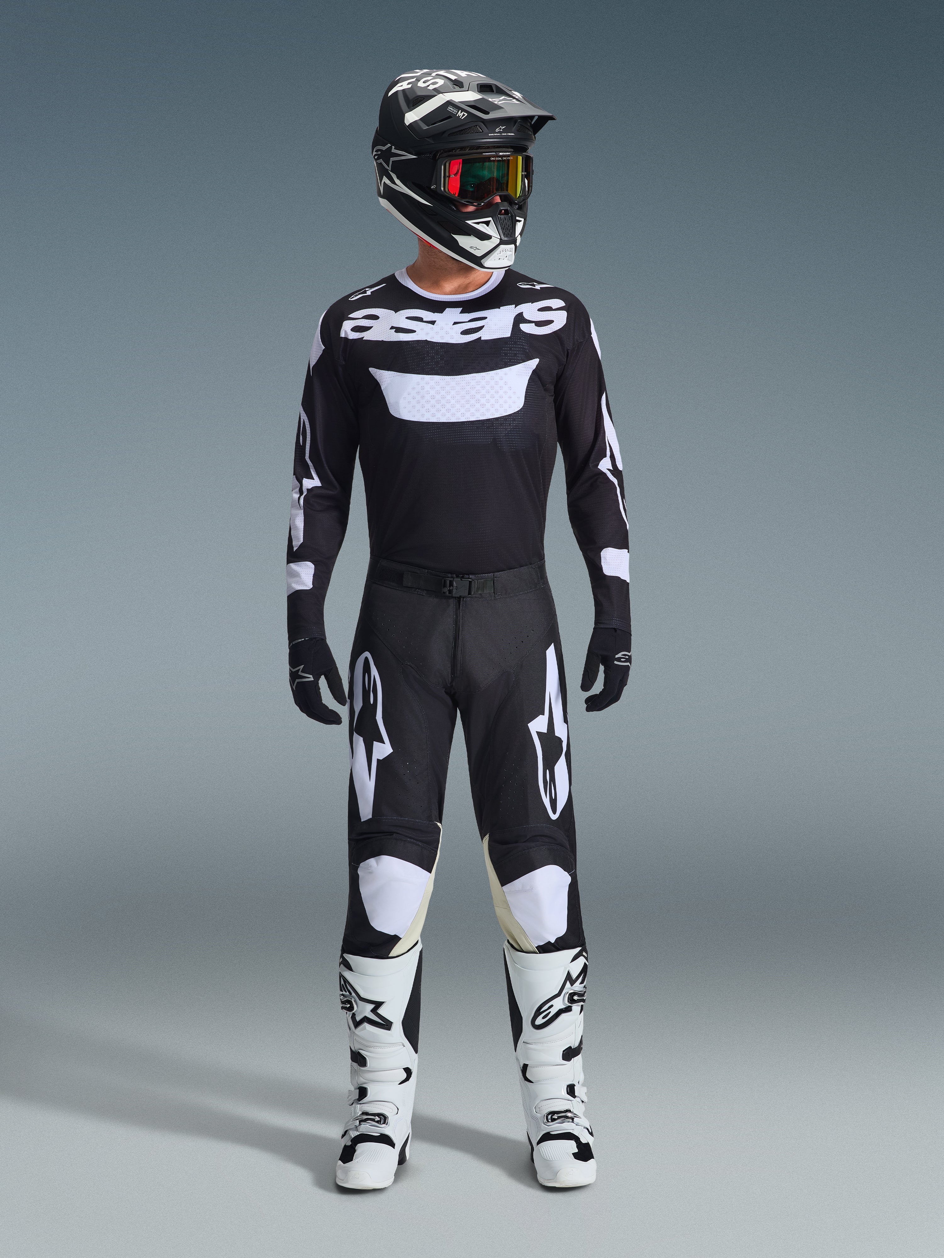 Alpinestars 2026 Racer Air Riway Gear Set, completo da motocross nero e bianco, maglia nera con logo 'astars' bianco, pantaloni coordinati con pannelli bianchi sulle ginocchia, stivali bianchi con fibbie nere, casco nero con maschera dalle lenti rosse, equipaggiamento professionale da gara fuoristrada