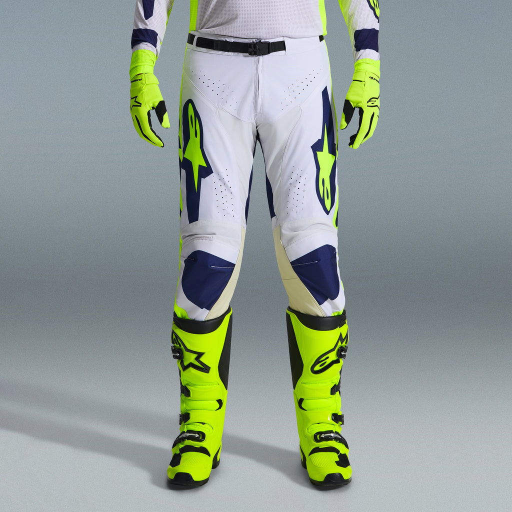 Alpinestars 2026 Racer Air Riway Gear Set, pantaloni da motocross in bianco e blu navy con accenti giallo neon, abbinati a guanti e stivali giallo neon coordinati, caratterizzati da design ergonomico e pannelli ventilati per corse off-road.