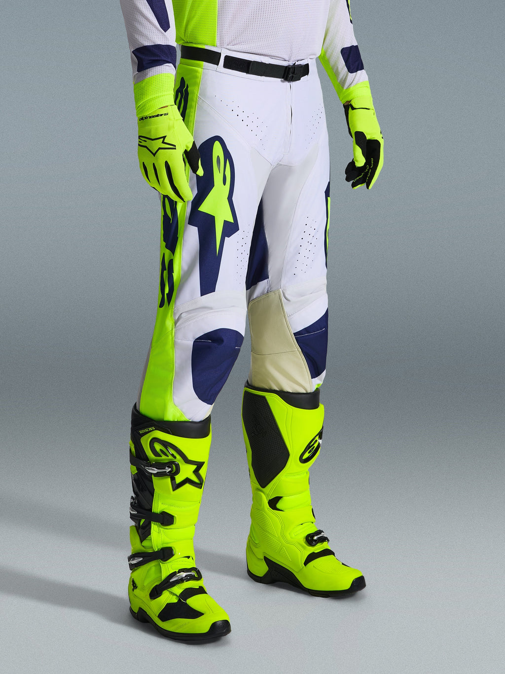 Alpinestars 2026 Racer Air Riway Gear Set, pantaloni da motocross bianchi con accenti blu navy e giallo fluo, abbinati a stivali e guanti coordinati giallo fluo, caratterizzati da traforature per il flusso d'aria e design ergonomico, completo professionale da gara off-road.