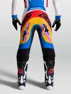 Alpinestars Pantaloni Supertech Dyna, pantaloni da motocross racing, design multicolore blu e giallo, materiale rip-stop elasticizzato leggero, indossati da modella