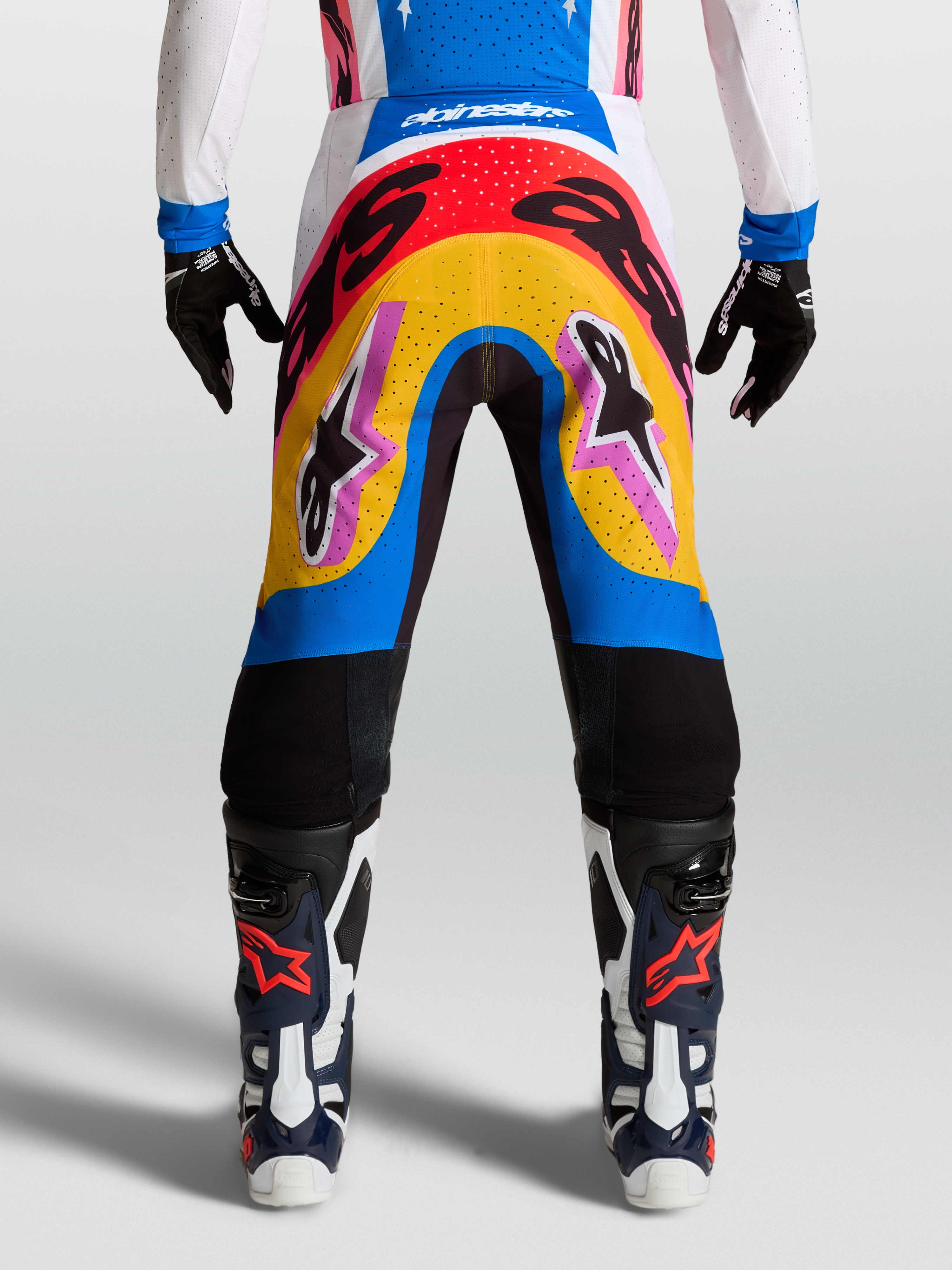 Alpinestars Pantaloni Supertech Dyna, pantaloni da motocross racing, design multicolore blu e giallo, materiale rip-stop elasticizzato leggero, indossati da modella