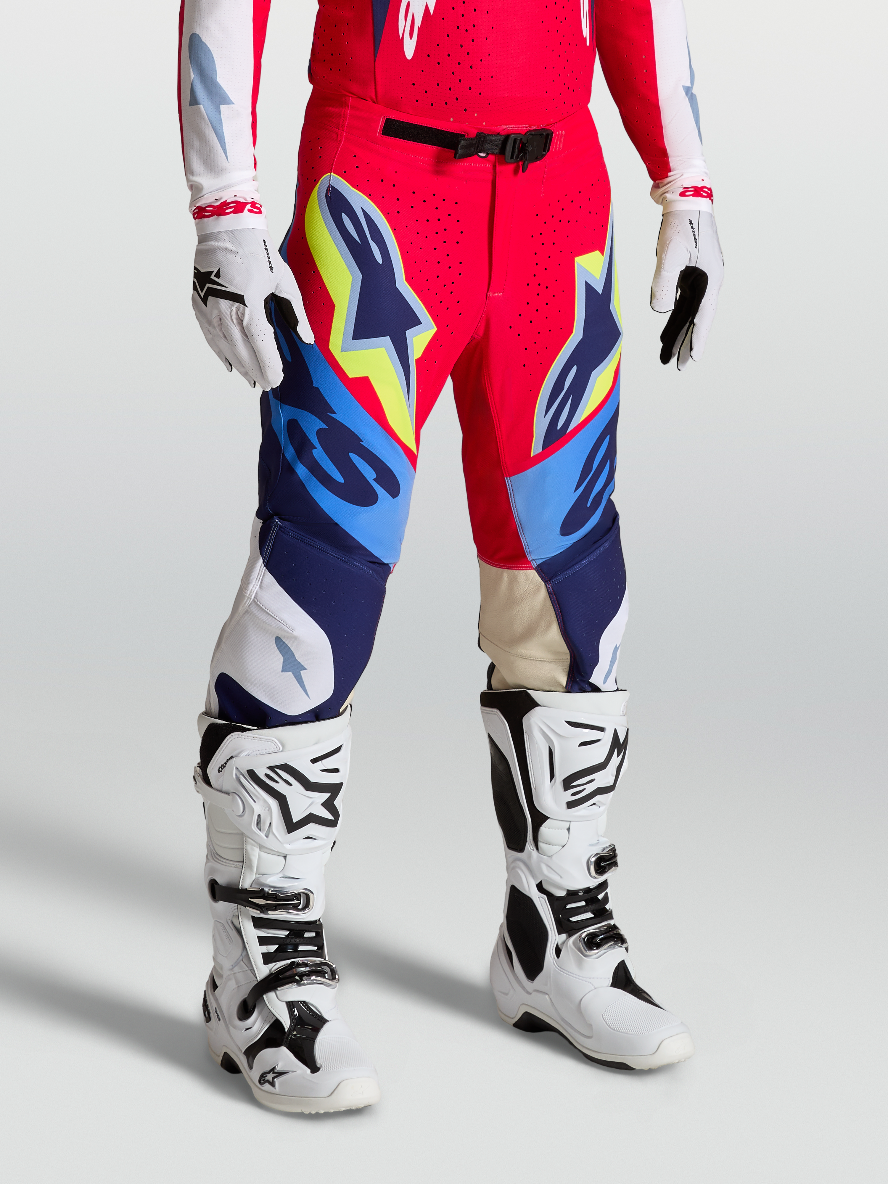 Alpinestars Pantaloni Supertech Dyna, pantaloni da motocross racing, rosso fuoco, bianco e blu navy, vestibilità atletica con fibbia magnetica e ginocchia in pelle, indossati con stivali e guanti bianchi
