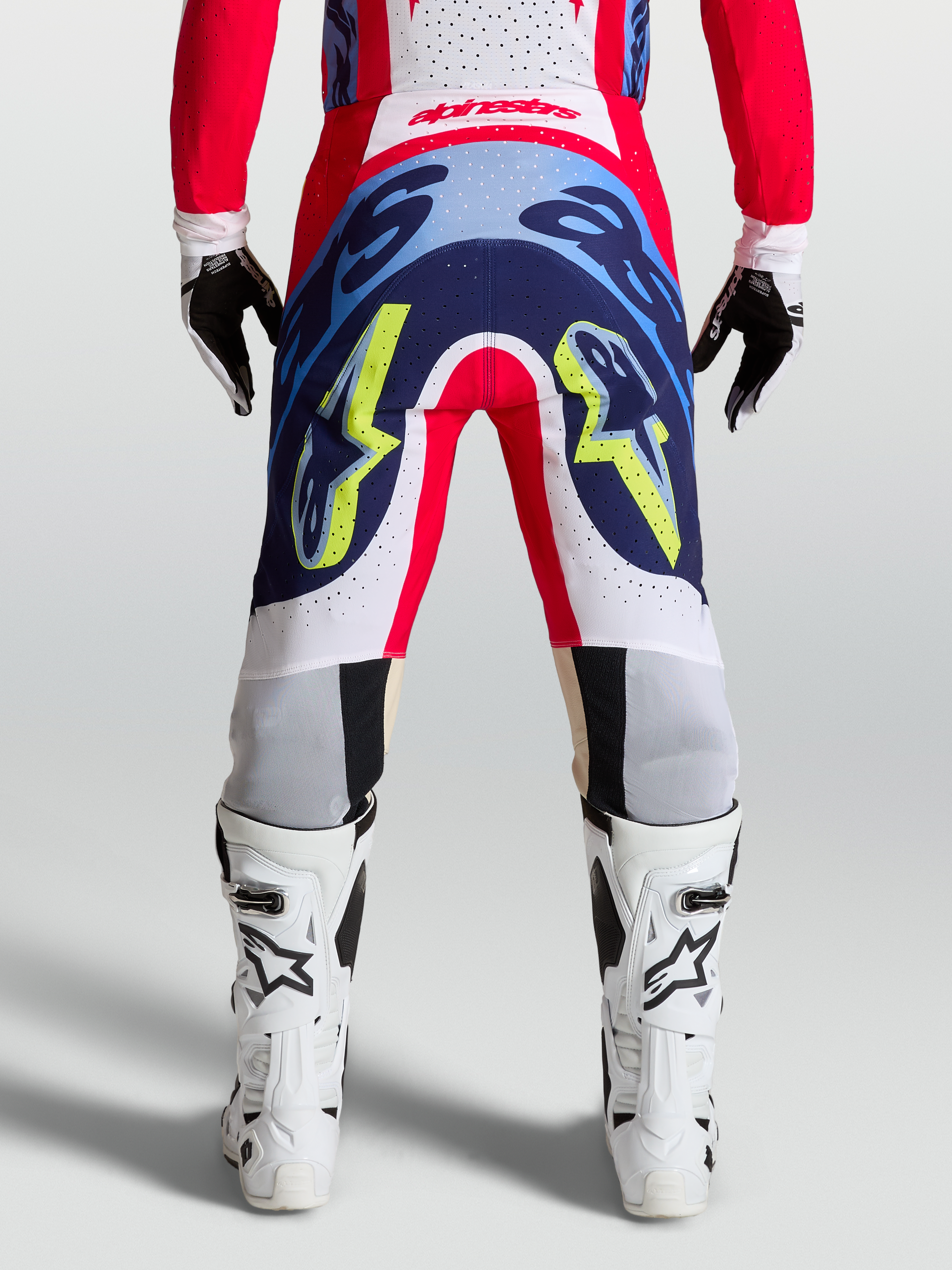 Alpinestars Pantaloni Supertech Dyna, pantaloni da motocross professionali, rosso fuoco, bianco e blu navy, vista posteriore con costruzione stretch resistente per performance racing