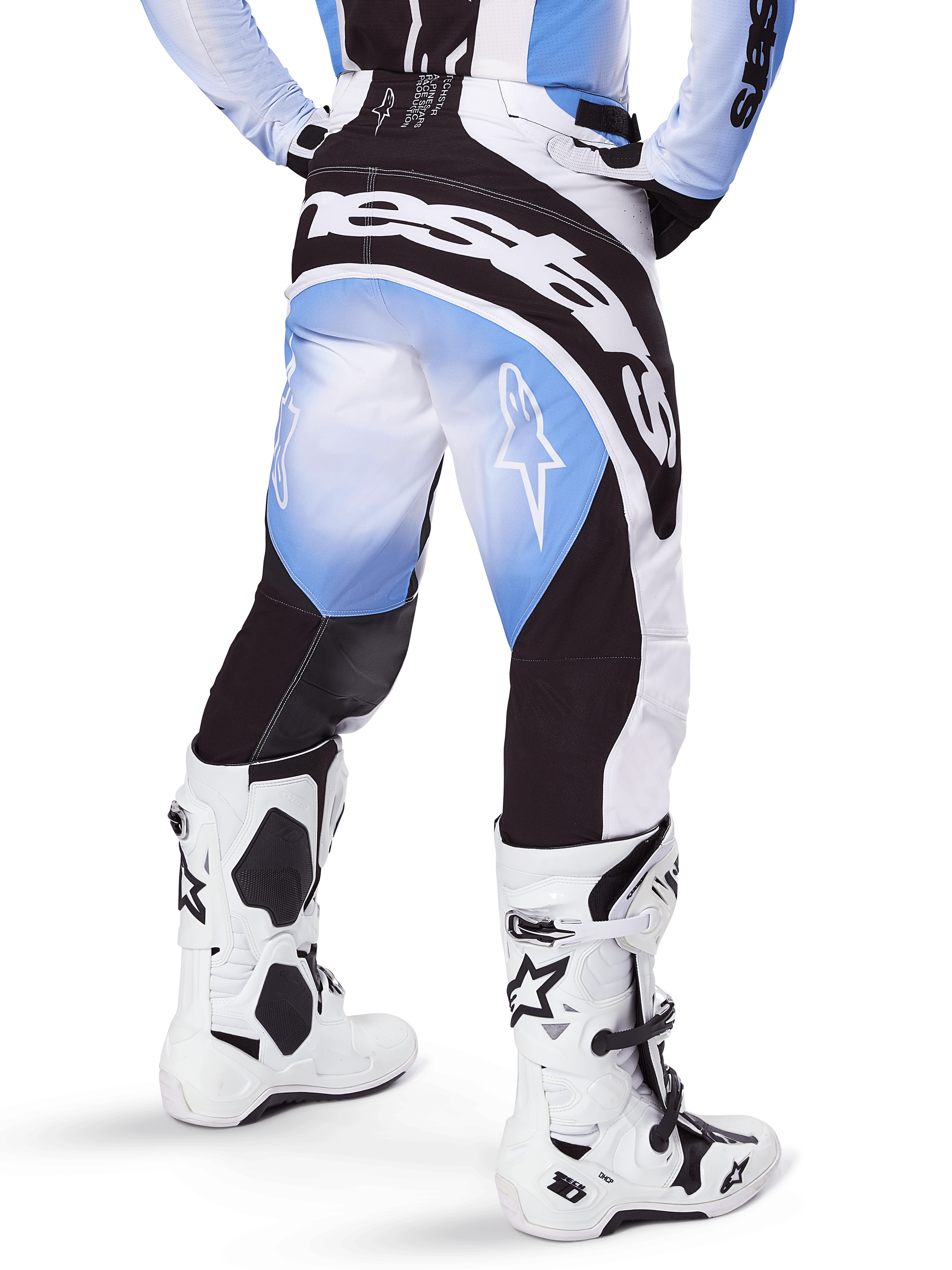 Alpinestars 2025 Techstar Melt Pants, pantaloni da motocross, nero, blu e bianco, vista posteriore con grande marchio Alpinestars sulla seduta e loghi a stella sulle gambe, indossati con stivali Tech 10 bianchi e neri, abbigliamento professionale da gara fuoristrada