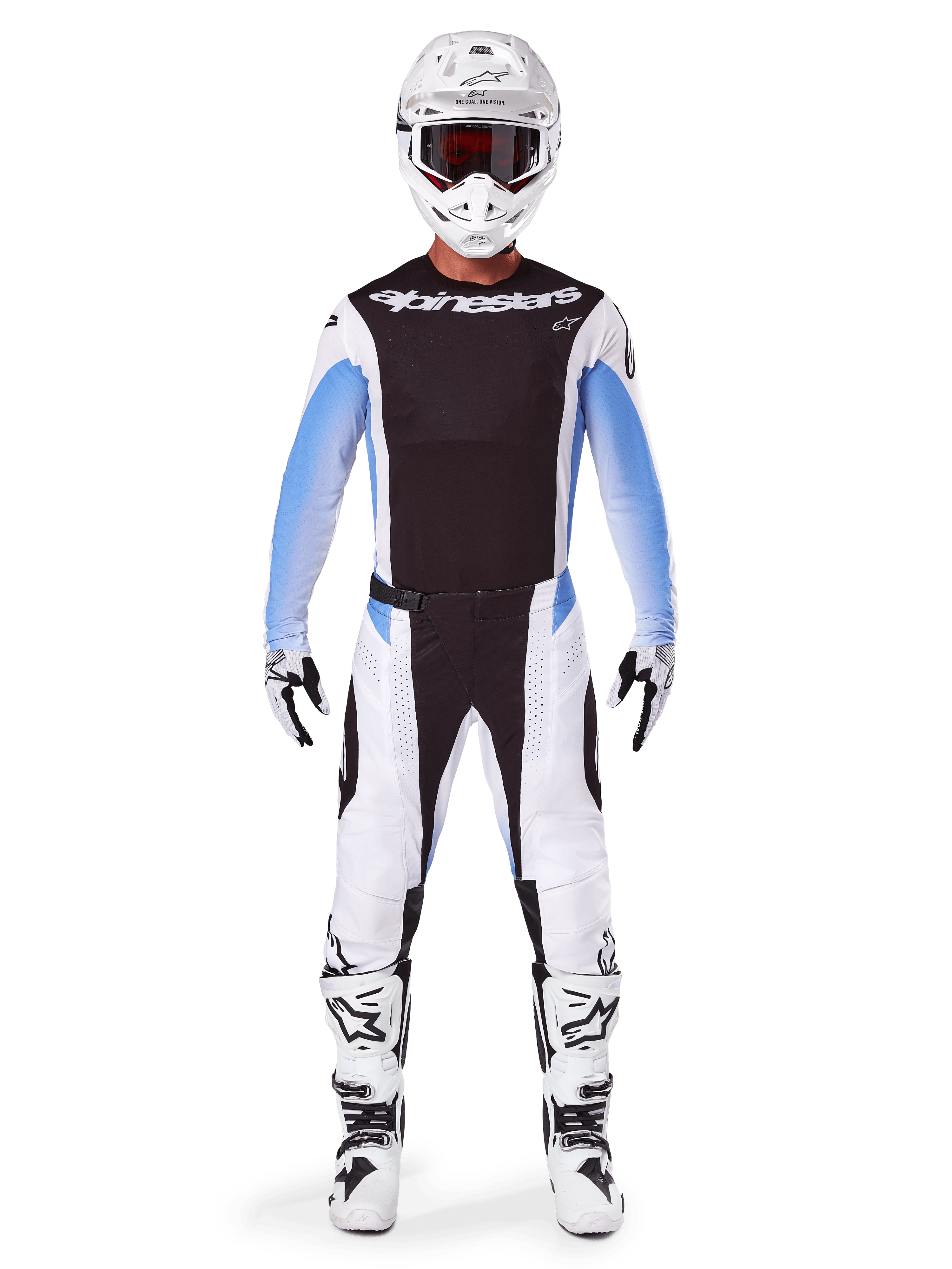 Pilota di motocross che indossa pantaloni Alpinestars 2025 Techstar Melt, pantaloni da motocross, nero e blu, design multi-pannello bianco e nero con accenti blu sui fianchi, indossati con maglia bianca coordinata, casco bianco, guanti bianchi e stivali per un kit completo da gara off-road