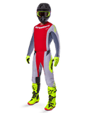 Pilota di motocross con il set Alpinestars Techstar Melt Gear 2025, maglia e pantaloni rossi e grigi, guanti e stivali giallo neon, casco nero, kit completo per gare fuoristrada