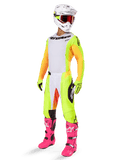 Set completo da motocross Alpinestars 2025 Techstar Melt, maglia bianca con maniche gialle e arancioni, pantaloni giallo neon, stivali rosa brillante, casco bianco con occhiali rossi, guanti gialli, abbigliamento da gara vivace e colorato