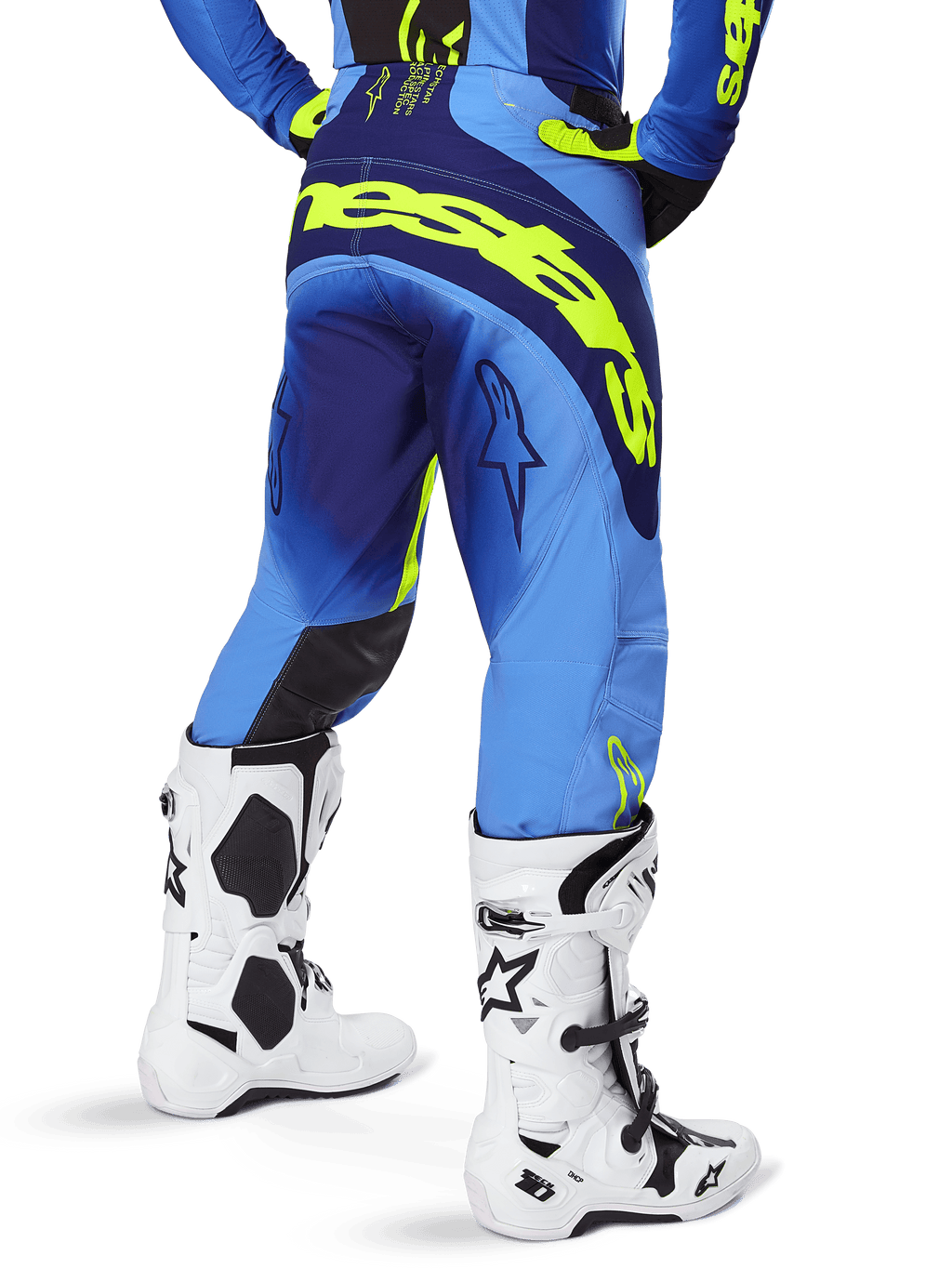 Alpinestars 2025 Techstar Melt Pants, pantaloni da motocross, Giallo Fluo Blu, vista posteriore con grande marchio giallo sulla seduta e dettagli blu scuro, indossati con stivali bianchi Alpinestars Tech 10 e maglia coordinata.