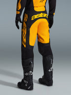 Alpinestars 2026 Racer Riway Pants, pantaloni da motocross, giallo e nero, vista posteriore che mostra il marchio astars giallo sulla seduta e sulla gamba, abbinati a stivali e guanti da motocross neri