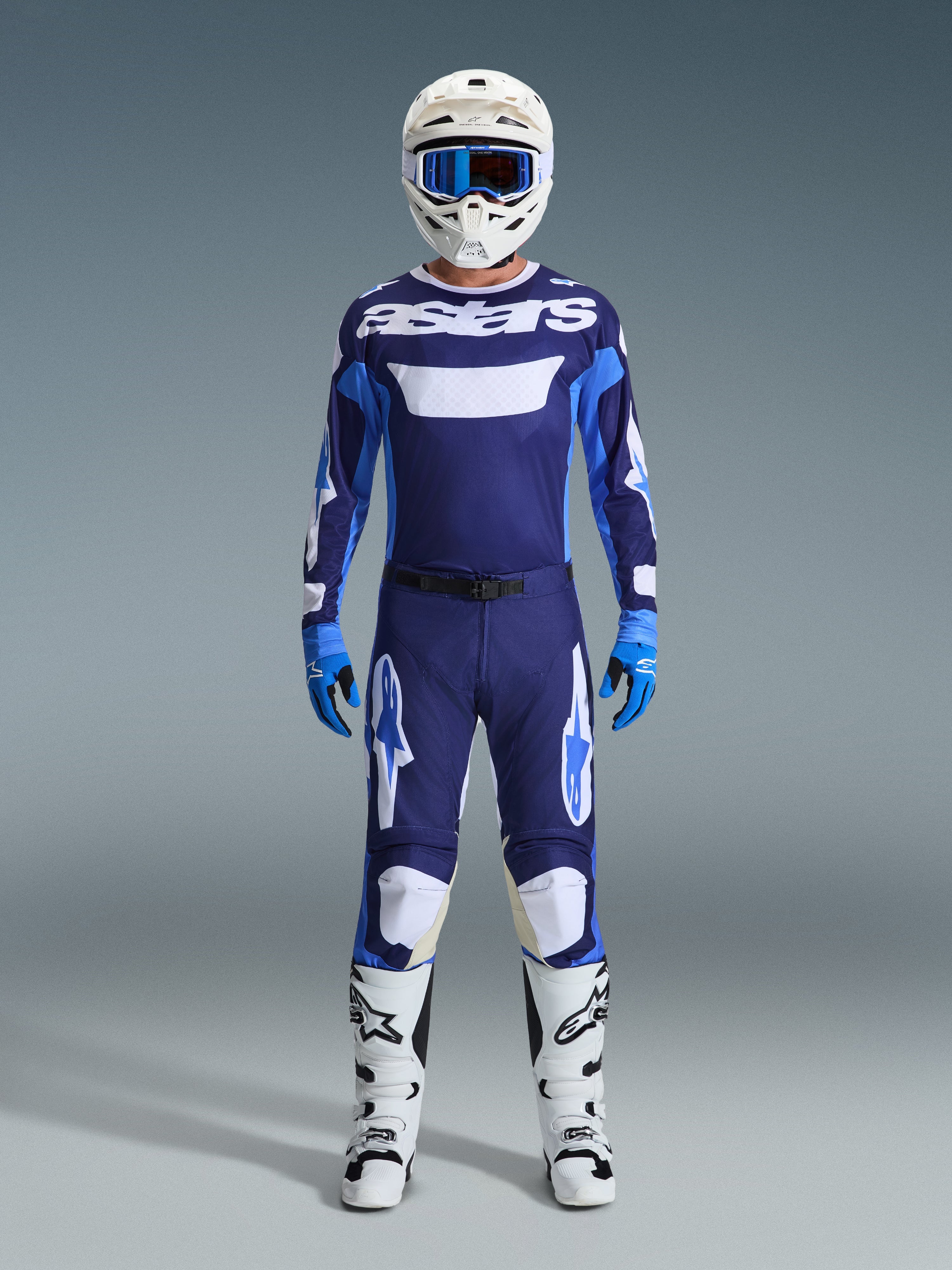 Alpinestars 2026 Racer Riway Gear Set, completo da motocross, maglia blu navy e azzurra con scritta 'astars' bianca, pantaloni coordinati con dettagli bianchi, casco bianco con maschera blu e stivali off-road bianchi