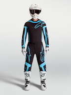 Alpinestars pantaloni Supertech Vesta, pantaloni da motocross da uomo, neri e turchesi, tessuto stretch leggero e vestibilità atletica, indossati da un modello